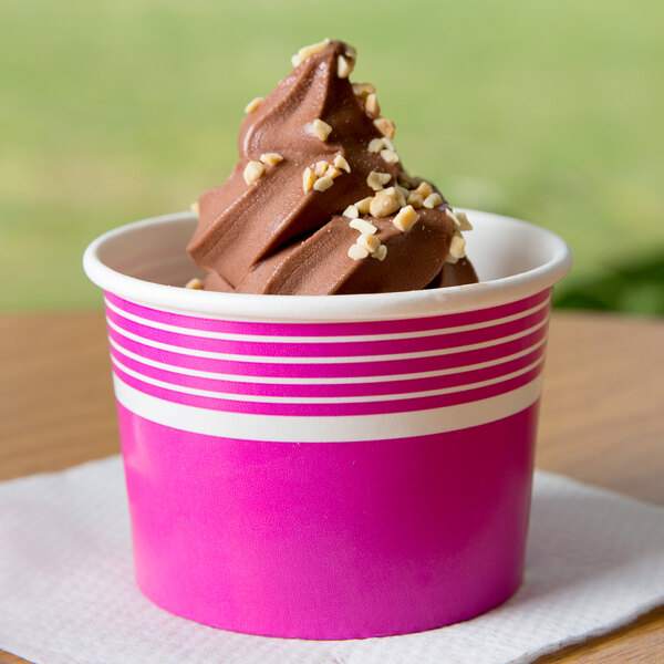 A pink Choice paper cup filled with chocolate ice cream and nuts.