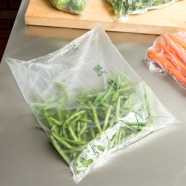 A plastic Inteplast Group produce bag filled with green beans and carrots.