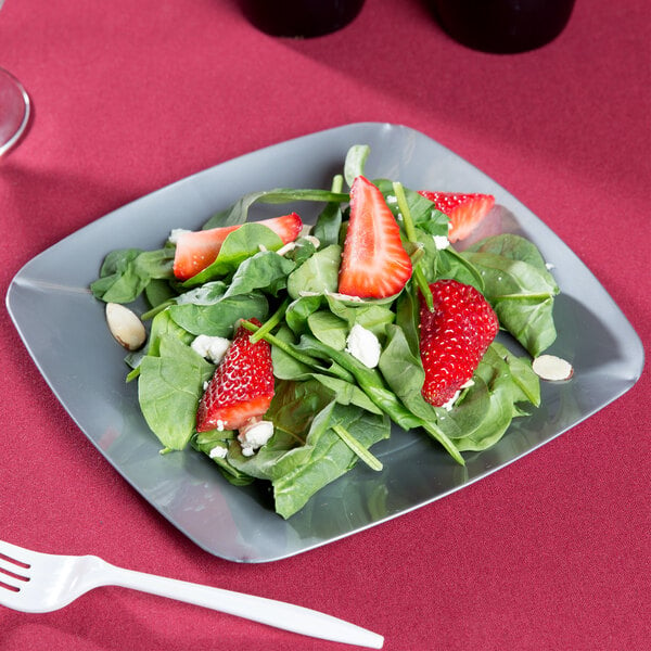 A Fineline silver square plastic salad plate with salad, strawberries, and spinach.