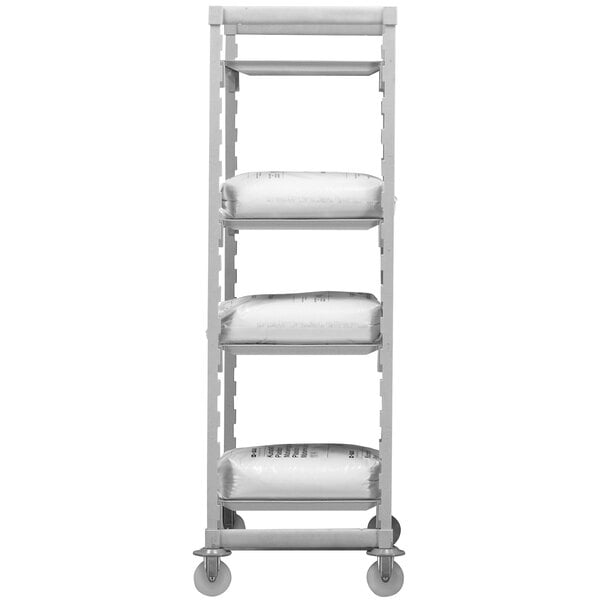 A white Cambro Camshelving® Premium mobile shelving unit with gray shelves holding white plastic bags.
