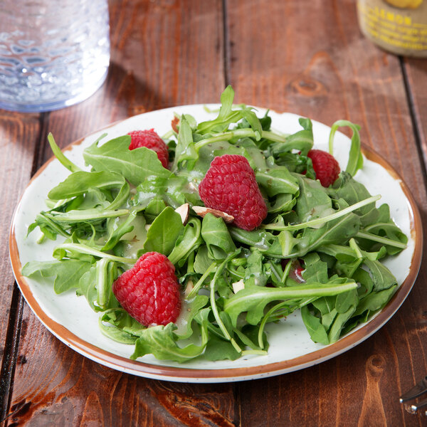 A GET Rustic Mill melamine plate with a salad of lettuce, raspberries, and nuts.