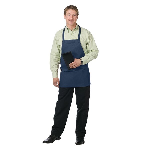 A man wearing a navy blue Chef Revival bib apron with 3 pockets in a professional kitchen.