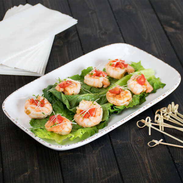 A white rectangular platter with shrimp, tomatoes, and sprouts on it.
