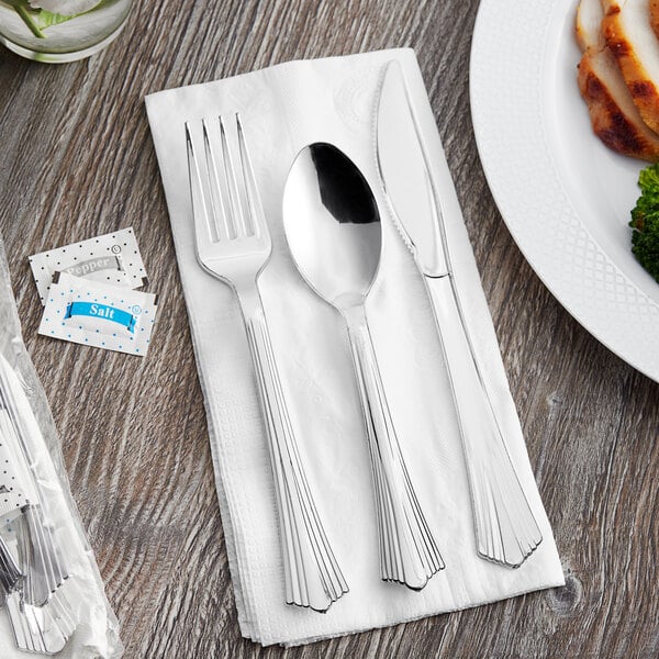 A Visions heavy weight plastic fork and spoon wrapped in a white napkin.