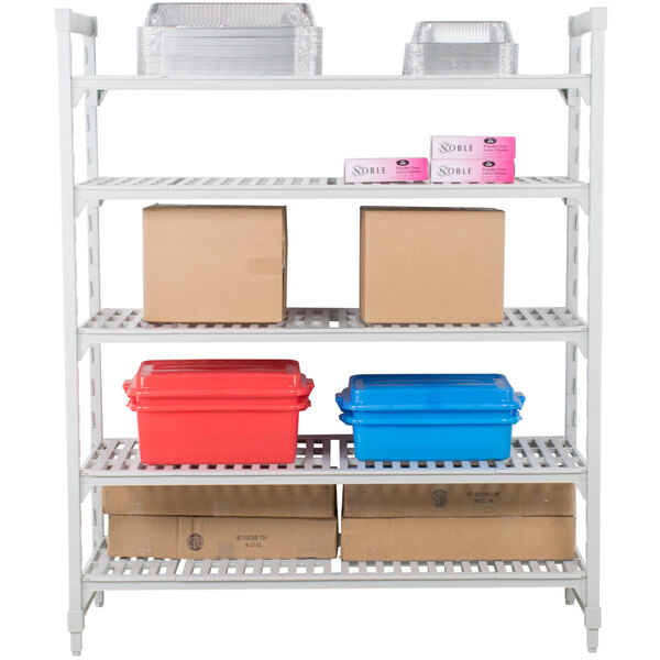 A white Cambro metal shelving unit with vented shelves holding boxes and plastic containers.