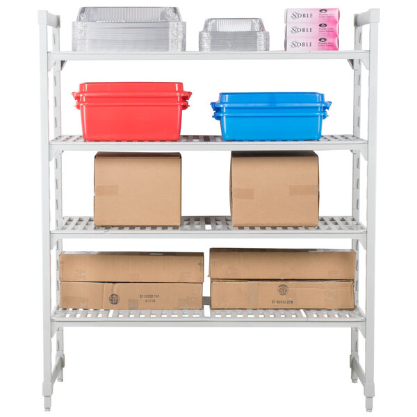 A white Cambro Camshelving® Premium shelving unit with vented shelves holding brown, blue, and red containers and brown cardboard boxes.