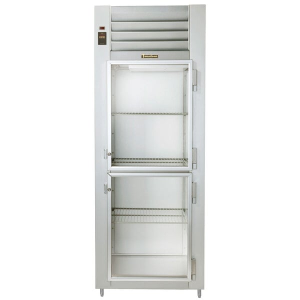 A white Traulsen reach in heated holding cabinet with glass half doors and shelves.