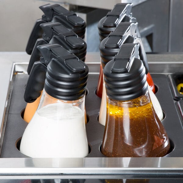 A Tablecraft black tray with several Tablecraft Tritan dispensers filled with condiments.