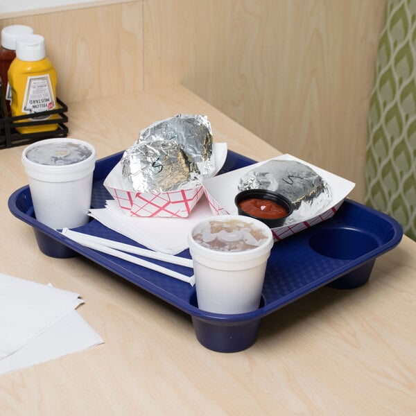 A cobalt blue polypropylene tray with a white cup and a plate of food on it.