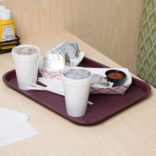 A burgundy plastic fast food tray with food on it on a table.