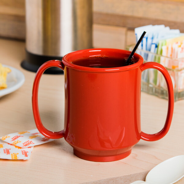 A close-up of a red GET Tritan plastic two handle mug.