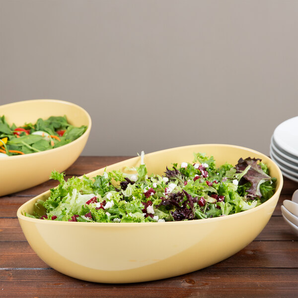 A table set with two GET Osslo dijon melamine bowls filled with salad.