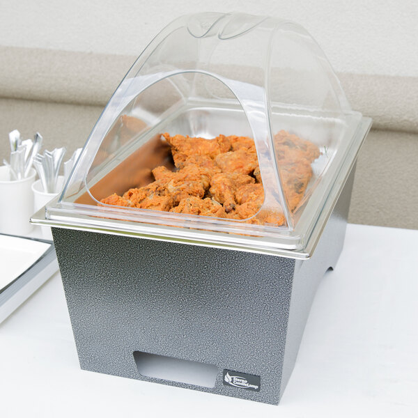 A Sterno full size chafer with food in a container and a clear cover on a table.