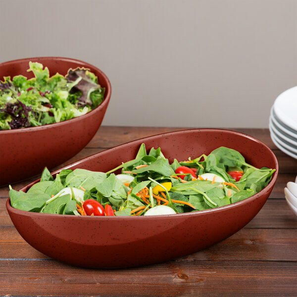 Two Osslo melamine bowls filled with salad on a table.