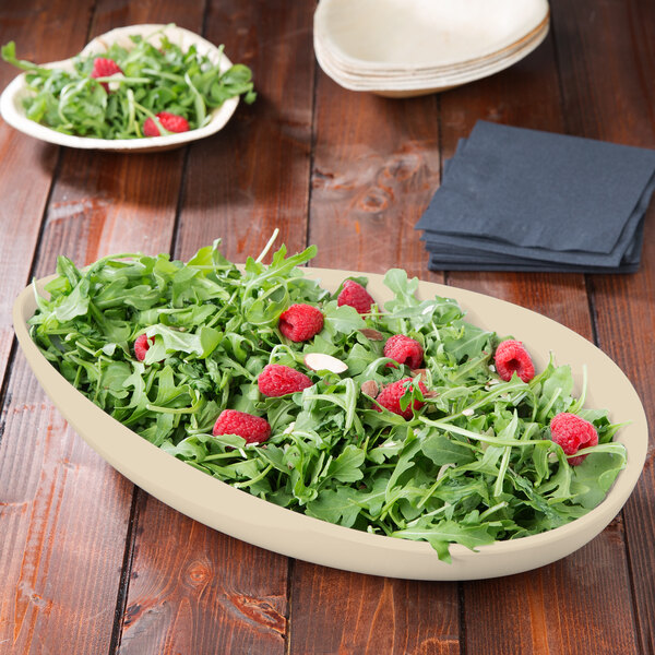 A Manila melamine bowl filled with green salad with raspberries.