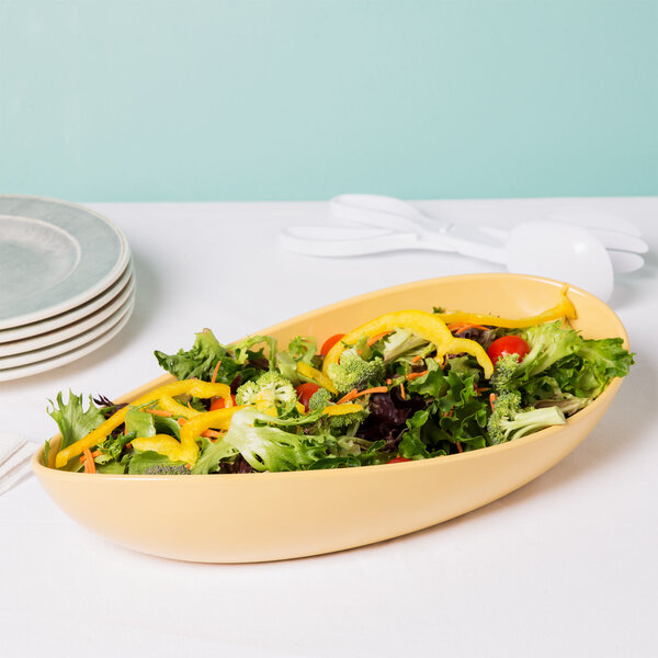 A bowl of salad with tomatoes, peppers, and broccoli in a yellow GET Osslo Dijon melamine bowl.