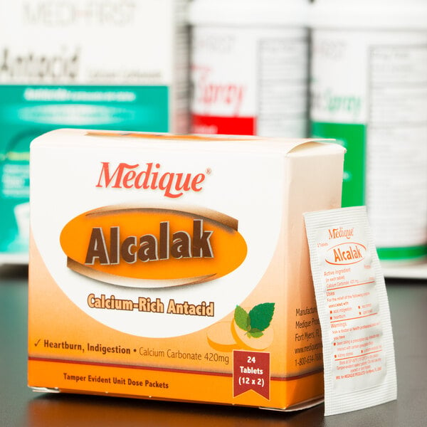 A white box of Medique Alcalak antacid tablets with red text.