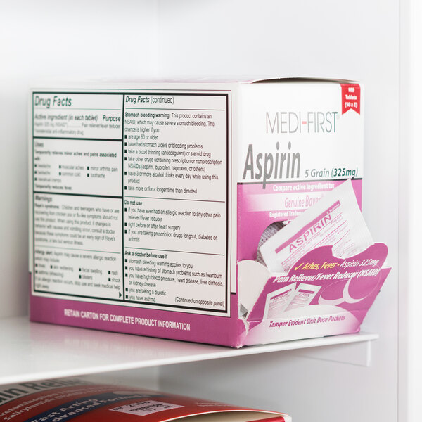 A Medi-First box of aspirin tablets on a shelf with a label.