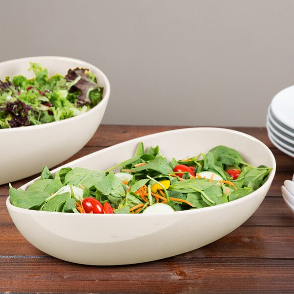Two Osslo oval melamine bowls of salad on a table.