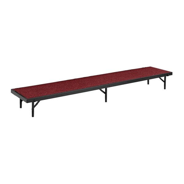 A red National Public Seating portable stage riser with black legs and a red carpeted platform.