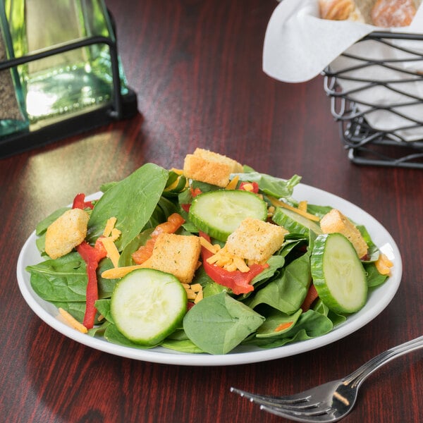 A Libbey Porcelana coupe plate with a salad of cucumbers and croutons.