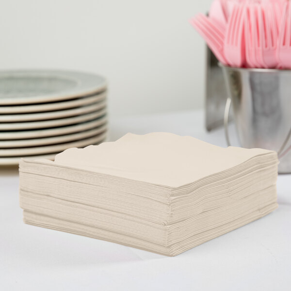 A stack of ivory Creative Converting paper napkins.