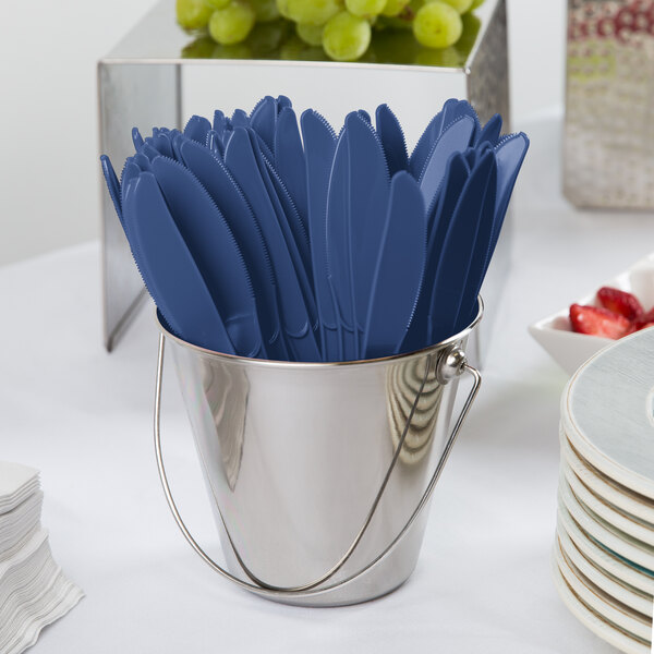 A blue bucket filled with navy blue plastic knives.