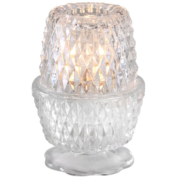 A Sterno Crawford clear glass candle holder with a lit candle.