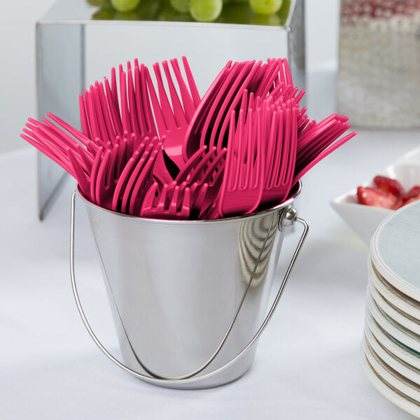 A bucket filled with Creative Converting hot magenta pink plastic forks.