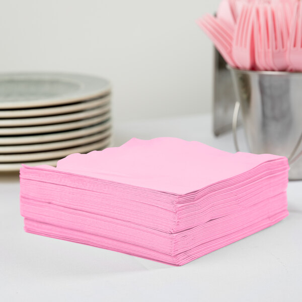 A stack of Creative Converting candy pink paper napkins.