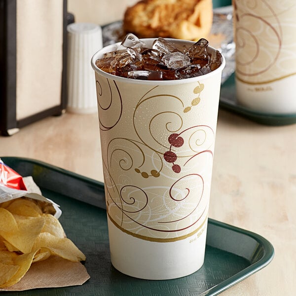 A tray with a Solo Symphony paper cold cup of soda and a bag of chips.