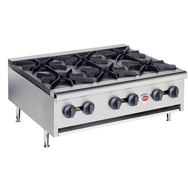 A large stainless steel Wells countertop gas range with six burners and black knobs.