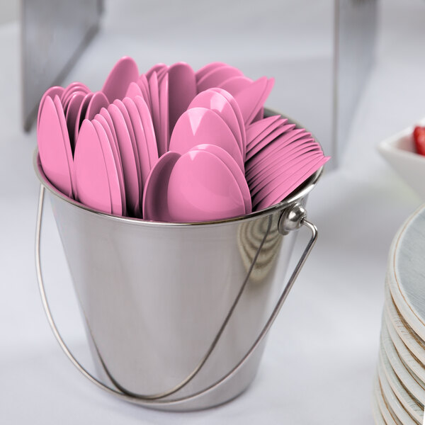 A bucket filled with Creative Converting candy pink plastic spoons.