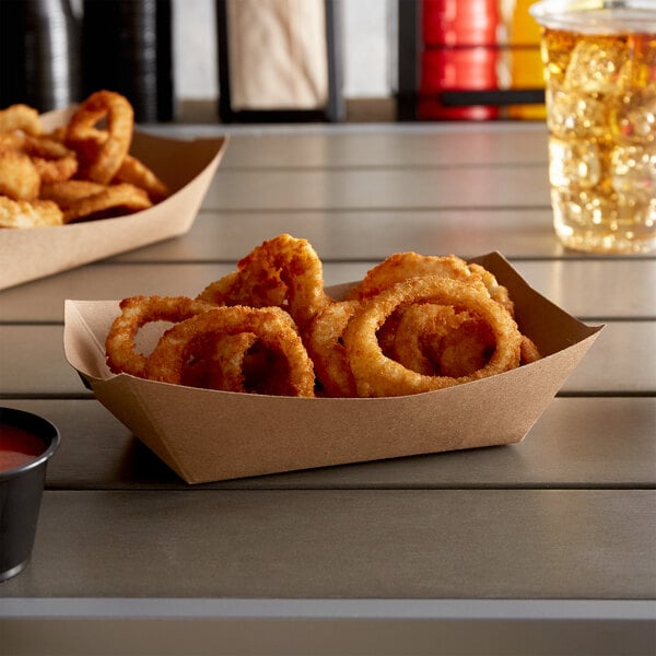 A tray of fried onion rings and a drink on a counter in a stadium concession stand.