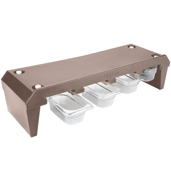 A brown plastic Cambro condiment rack with clear plastic containers inside.