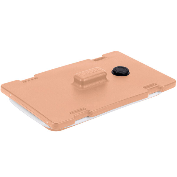 A tan plastic Cambro Camtainer lid with a black button.