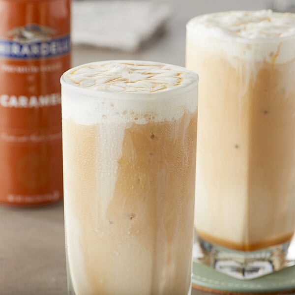 Two glasses of iced coffee with caramel flavoring sauce drizzled on top.