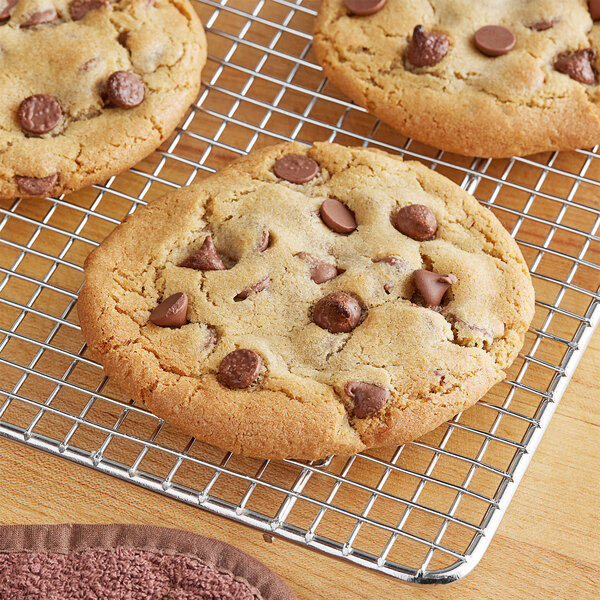 A cookie on a cooling rack with Ghirardelli milk chocolate chips.