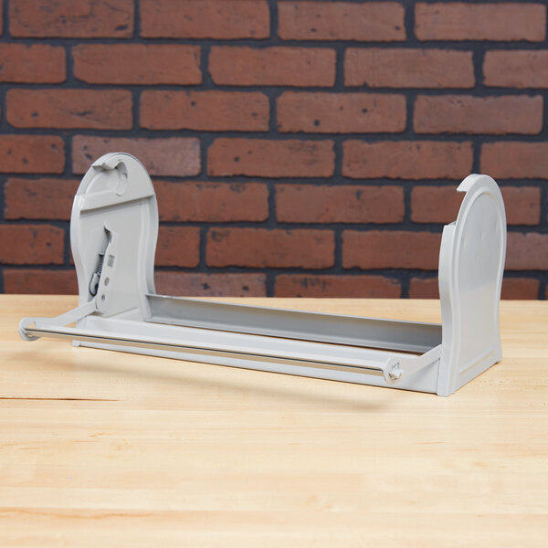 A gray steel Bulman all-in-one paper dispenser on a white table.