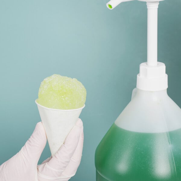 A gloved hand holding a white Genpak paper cone filled with green liquid.