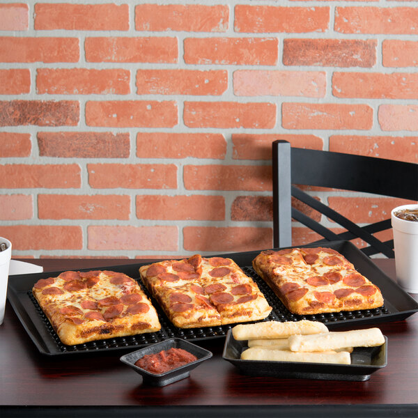 A square pizza on a black Polypropylene Pizza Pleezer tray on a table.