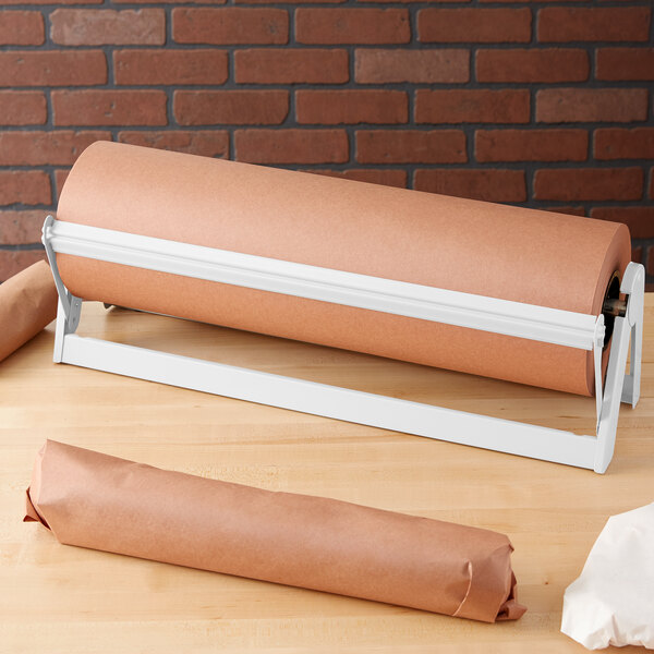A Bulman white paper dispenser holding a roll of brown paper on a table.