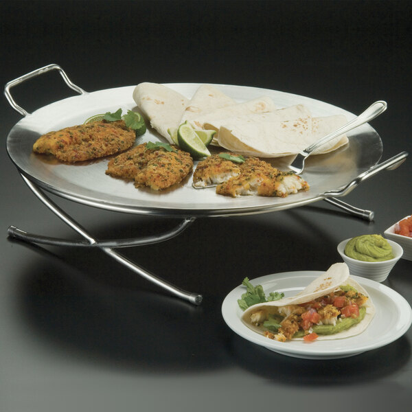 An American Metalcraft stainless steel griddle with food on it on a table.