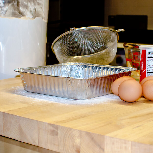 A Durable Packaging foil cake pan with eggs on a counter.