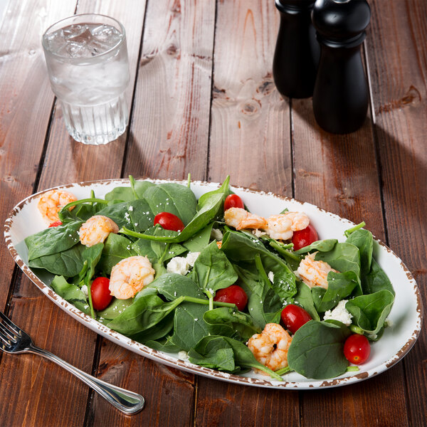 A Tuscan white melamine platter with salad, shrimp, and tomatoes on it.