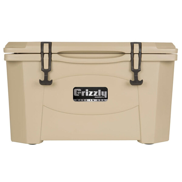 A tan Grizzly Cooler with black handles and a logo on the lid.