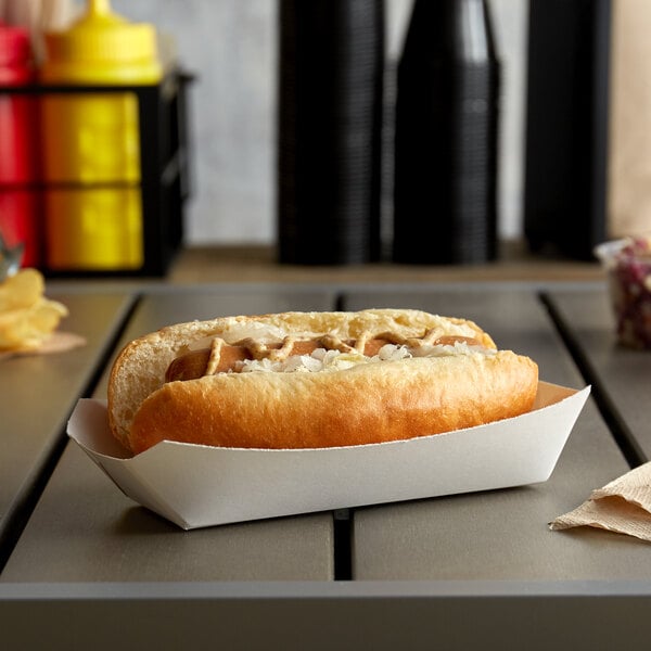 A hot dog in a white paper tray.