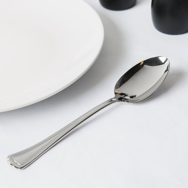 A Libbey stainless steel serving spoon on a white plate.