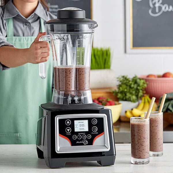 A woman using an AvaMix commercial blender to make a smoothie.