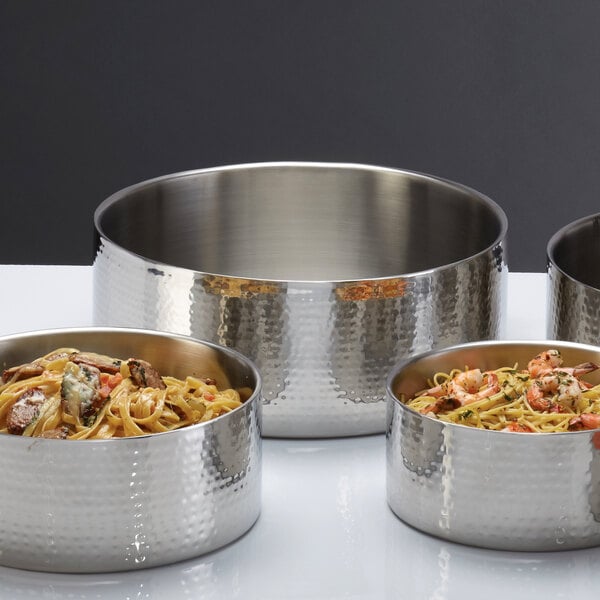 Three American Metalcraft stainless steel serving bowls with food in them.